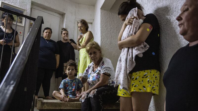 Israelis take shelter in the stairwell of their apartment building as a siren sounds a warning of incoming rockets fired from the Gaza Strip, In Ashdod, Israel, Wednesday, May 19, 2021 (AP Photo/Heidi Levine)&nbsp;