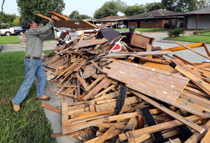 Jesus Ramirez after removing damaged wooden flooring from his home in Houston (David J, Phillip/AP)