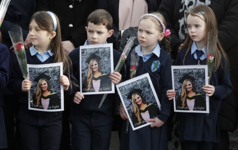 Pupils from Ashling Murphy's class hold photographs of her and red roses outside St Brigid's Church, Mountbolus, Co Offaly. Picture by Damien Eagers/PA Wire&nbsp;