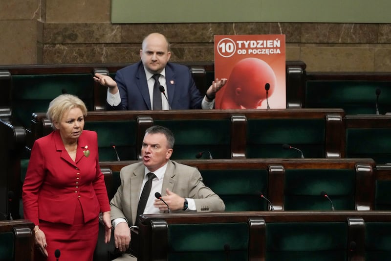 Dariusz Matecki, a conservative legislator in the Polish parliament, displays a poster during a debate on liberalising the abortion law (Czarek Sokolowski/AP)