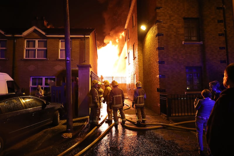 Firefighters dampen homes as a nearby bonfire at Ravenscroft Avenue in east Belfast is lit. Picture by PA Wire