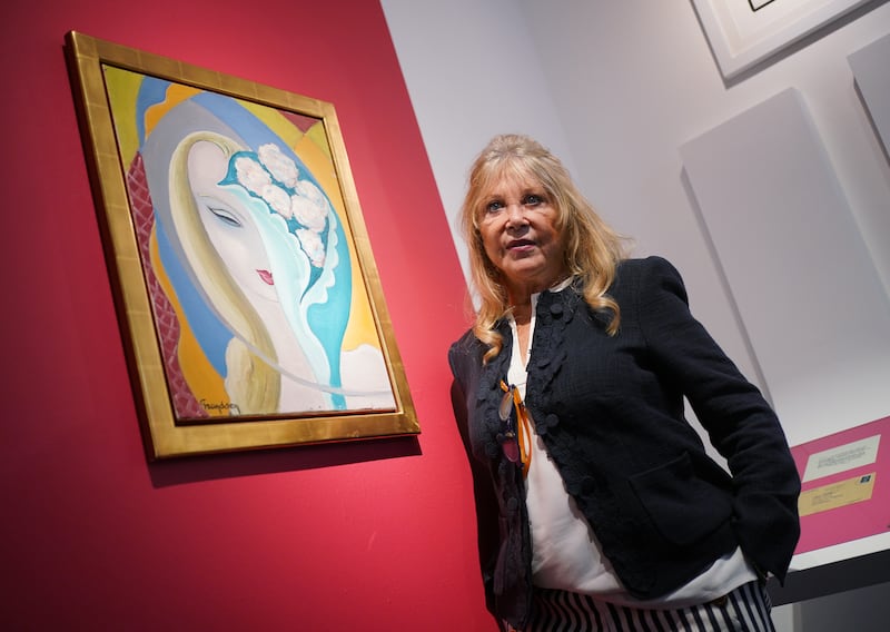 Pattie Boyd posing next to original cover art for the 1970 Derek and the Dominos album Layla and Other Assorted Love Songs
