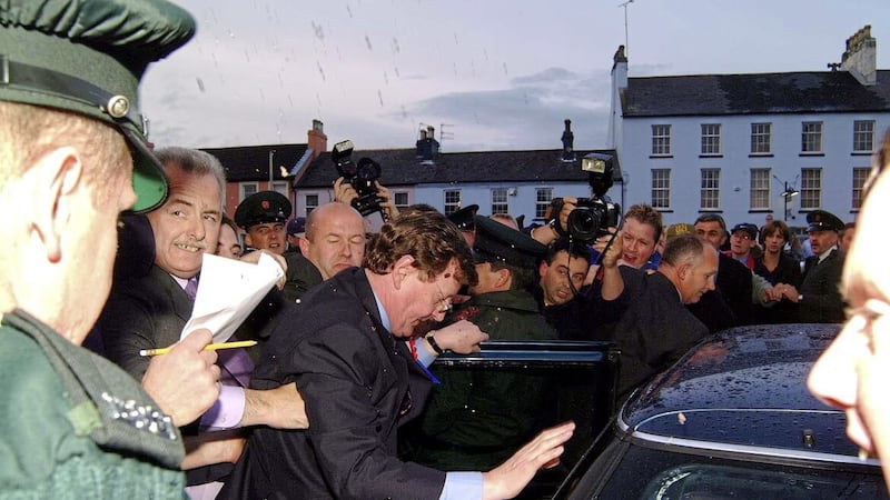 David Trimble is ushered to his car as protesters surge forward during a difficult election for the UUP 