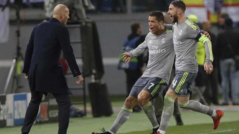 Real Madrid's Cristiano Ronaldo, center, celebrates with coach Zinedine&nbsp;Zidane, left, and Sergio Ramos after scoring the opening goal during their Champions League, Round 16, first-leg soccer match away to Roma