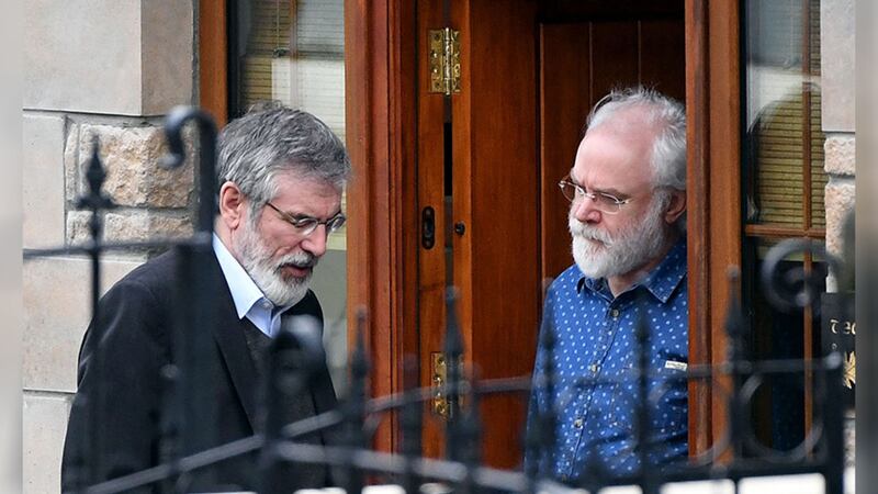 Gerry Adams speaks to a member of Martin McGuinness' family at his home in Derry yesterday. Picture by Niall Carson, PA