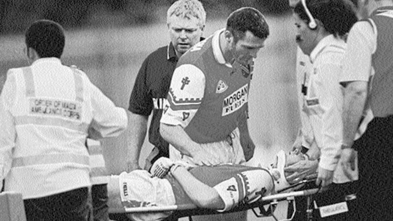 CONCERN... Armagh team captain Jarlath Burns and joint manager Brian McAlinden look on anxiously as the injured Alan O&rsquo;Neill is stretchered off by Order of Malta Ambulance Corps personnel during Sunday&rsquo;s USFC clash with Derry 