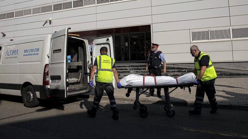 The attacker&#39;s body is taken on a stretcher by mortuary service members outside the police station near Barcelona on Monday. Picture by Emilio Morenatti/AP 