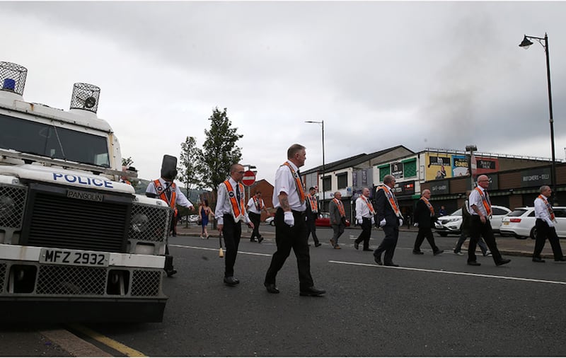 Orangemen marching past Ardoyne shops in north Belfast. Picture by Hugh Russell