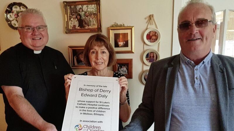 Children in Crossfire founder, Richard Moore (right) presented a copy of the commemorative plaque to the late Bishop Edward Daly&#39;s sister, Anne Gibson and long-time friend, Fr Eamon Graham.  