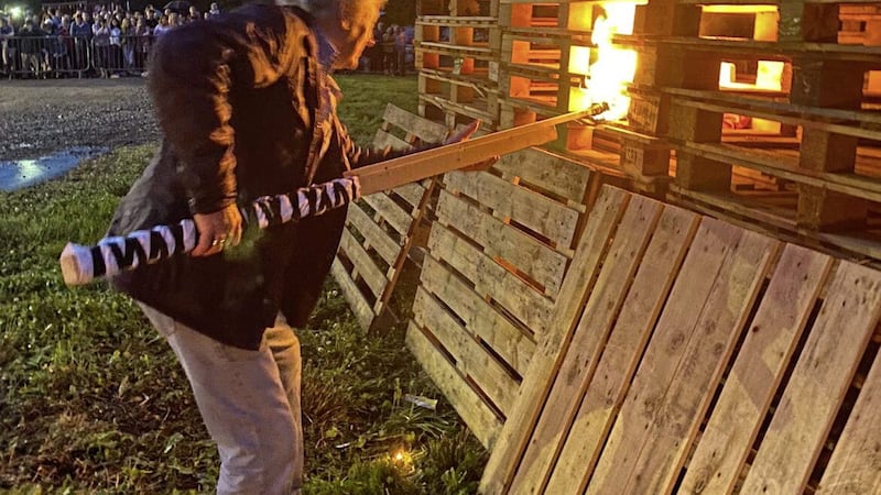 Fivemiletown District Orange Lodge shared images of Charlie Lawson setting the Roughan bonfire alight and posing in front of it 