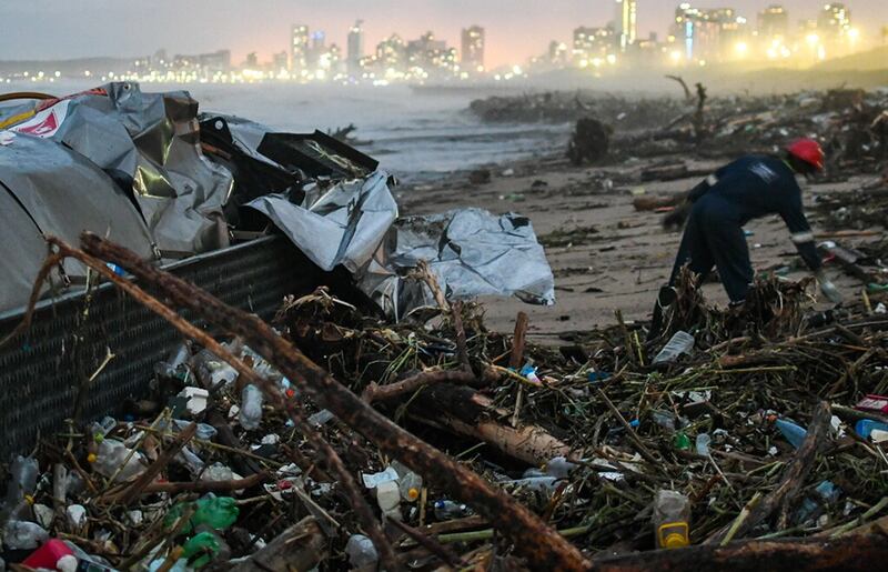 The wreckage of a road tanker lies among the rubbish washed up on a Durban beach. Eighteen rivers pass through the city on their way to the sea. The damage wrought by the flood on the popular tourist destination could be more than R25bn, a city official estimated. Picture: Gallo Images / Darren Stewart