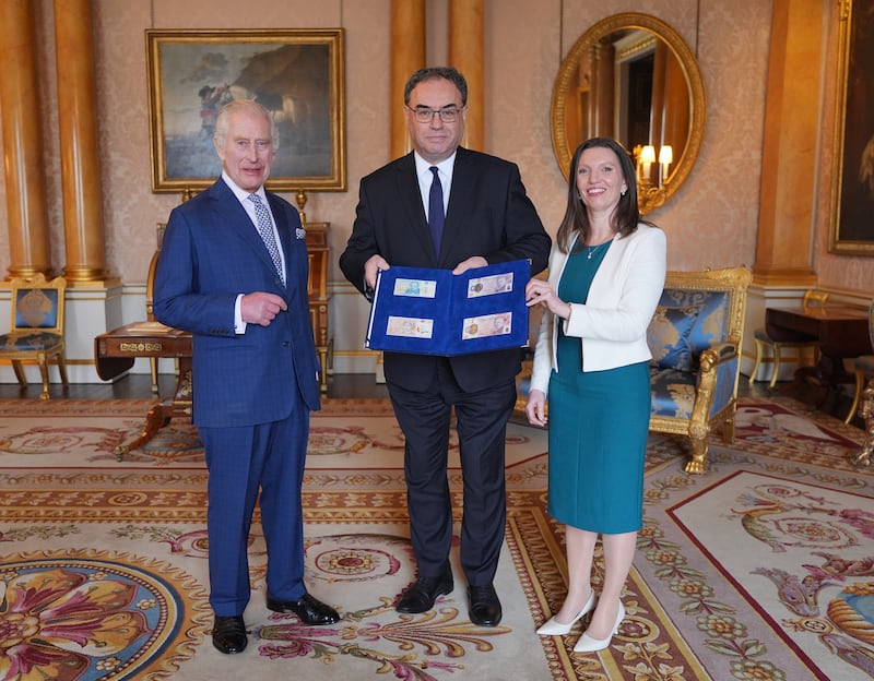 The King poses with the new notes presented by Bank of England Governor Andrew Bailey and Chief Cashier Sarah John