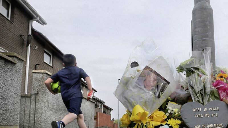 A boy runs past tributes left at the scene where Lyra McKee was murdered in the Creggan estate of Derry city on Thursday night. Picture Margaret McLaughlin 