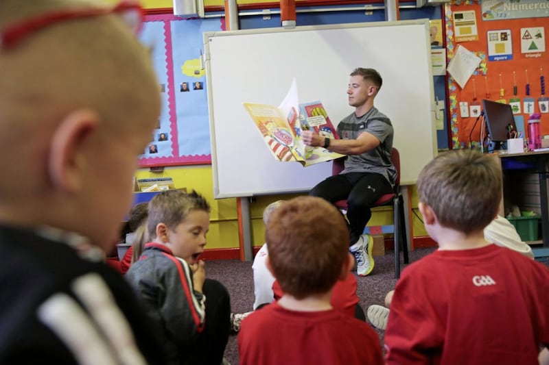 Tyrone footballer Mark Bradley reads to P1 pupils at St Mary&#39;s PS, Pomeroy. Picture by Hugh Russell 