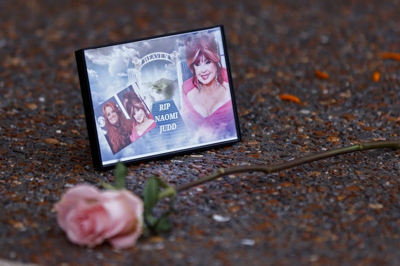 A photograph of Naomi Judd lays with a rose outside the Country Music Hall of Fame before the medallion ceremony in Nashville, Tennessee 