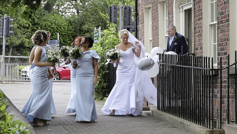 Bride Frances Nugent emerging from her home on Donegall Street to walk to her wedding in St Patrick&#39;s Church on Donegall Street. Picture by Hugh Russell 