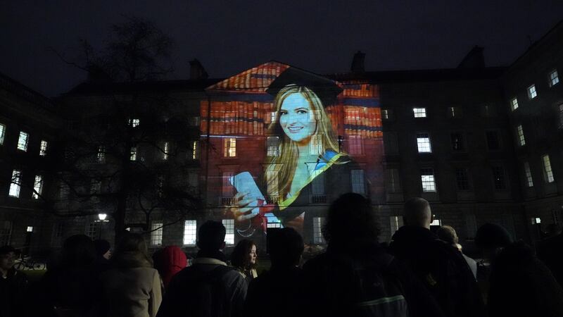 Crowds look at a projection of murdered teacher Ashling Murphy on the walls of Trinity College Dublin (Niall Carson/PA)