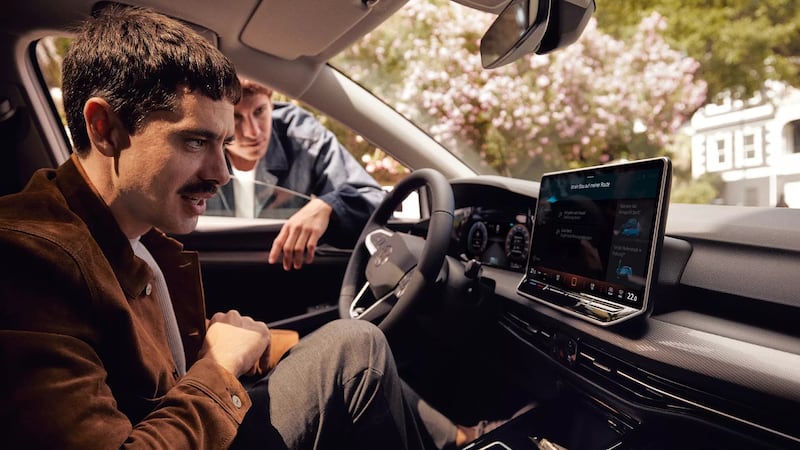 A photo of a man using the Volkswagen Golfs ChatGPT-enhanced voice controls
