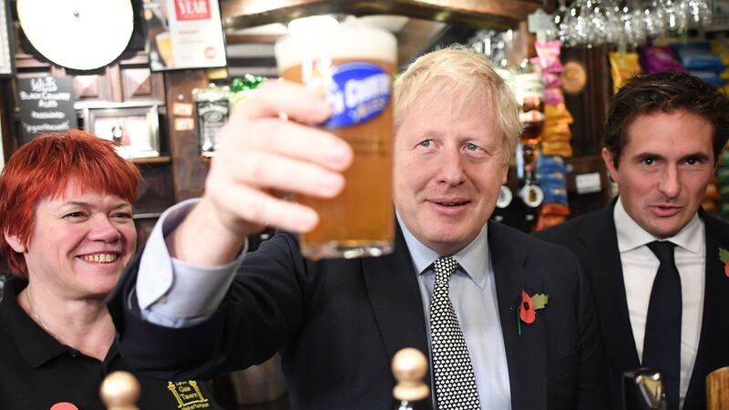 Boris Johnson, after pulling a pint watched by British defence minister Johnny Mercer (right) as he meets with military veterans at the Lych Gate Tavern in Wolverhampton&nbsp;