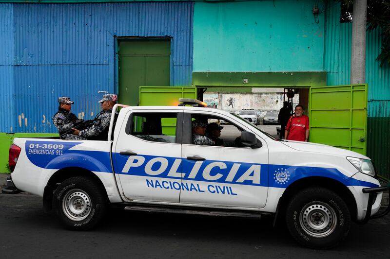 Police stand guard outside a polling station as electoral workers deliver ballot papers in the capital San Salvador (Moises Castillo/AP)