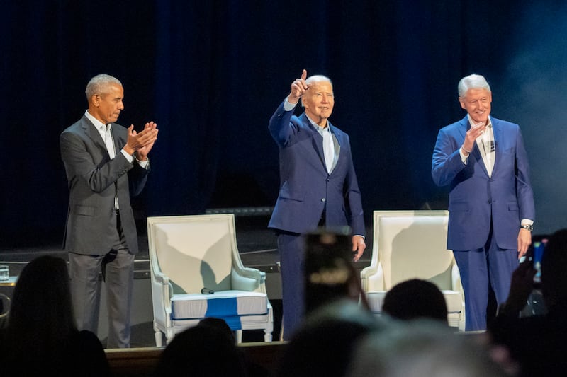 President Joe Biden, centre, and former presidents Barack Obama, left, and Bill Clinton on stage (Alex Brandon/AP)