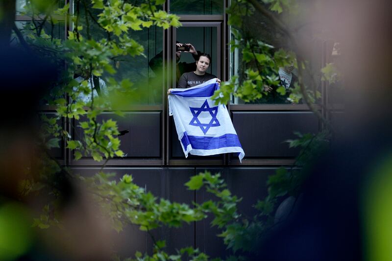 A man shows an Israeli flag during a pro-Palestinian demonstration by the group Student Coalition Berlin (MArkus Schreiber/AP)