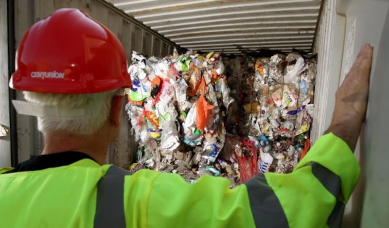 A worker looking at plastic rubbish