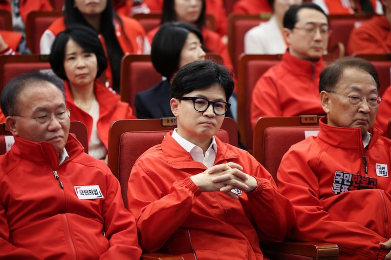 The ruling People Power Party’s leader Han Dong-hoon, center, and party members watch TV broadcasting results of exit polls for the parliamentary election at the National Assembly (Kim Hong-Ji/Pool Photo via AP)