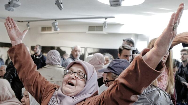 Ediba Salihovic raises her hands in joy and relief as she reacts along with other Bosnian women upon hearing Bosnian Serb military chief General Ratko Mladic being convicted of genocide. She was watching the verdict at the memorial centre in Potocari, near Srebrenica in Bosnia and Herzegovina, where Mladic&#39;s troops killed more than 8,000 men. Picture by AP Photo/Amel Emric 