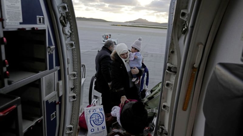 A refugee family embark to an aircraft before their flight to France from the Athens International Airport under a European relocation program PICTURE: Thanassis Stavrakis/AP 