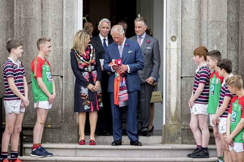 The Prince of Wales looks at the Ulster rugby and Armagh GAA county jersey he was presented by pupils from The Royal School, Armagh, and St Patrick&#39;s Grammar School, Armagh, following an engagement at Palace Demense in Co Armagh Picture by Liam McBurney/PA 