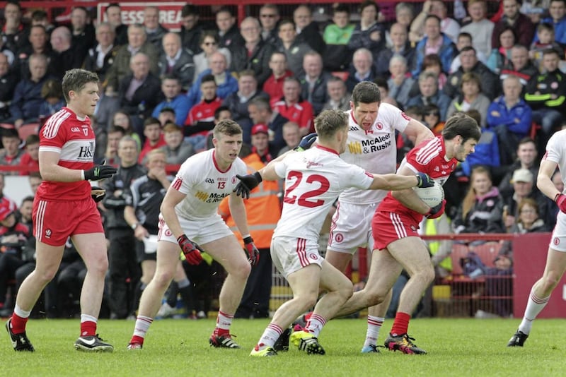 Derry's Karl McKaigue is mobbed by Tyrone's Sean Cavanagh, Kieran McGeary and Connor McAliskey during last year's Ulster Senior Football Championship quarter-final at Celtic Park<br /> Picture by Margaret McLaughlin