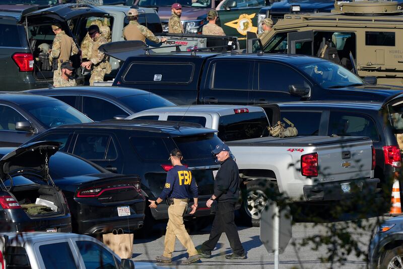 Police in a school parking lot during the manhunt for Robert Card in October 2023 (Matt Rourke/AP)