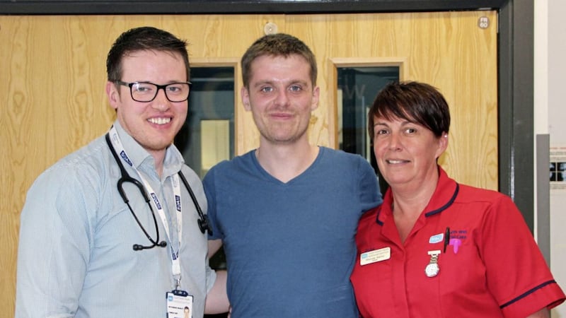 Surfer Matthew Bryce (centre) with consultant Dr Padraig Headley (left) and ward sister Rhonda Marks. Picture from South Eastern Health &amp; Social Care Trust 