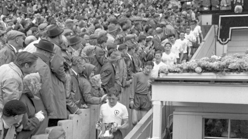 File photo dated May 5 1962 of Spurs right-half and captain Danny Blanchflower, holding the FA Cup, as he leads his men past back-slapping fans on the way down from the Royal Box at Wembley. Spurs beat Burnley 3-1 in the Cup Final. Picture by PA/PA Wire. 