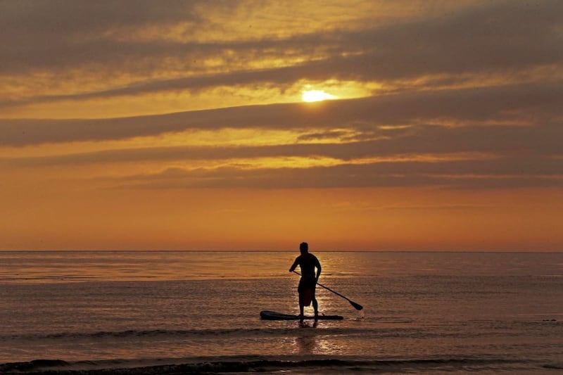 A paddle boarder enjoys the sunrise at Helen's Bay, Co Down. Picture by Mal McCann