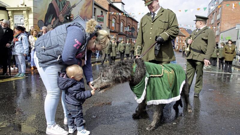 A young boy gives the Irish wolfhound mascot a snack at the start of the main Belfast Easter parade, organised by the National Graves Association, at Beechmount Avenue. Picture by Cliff Donaldson 