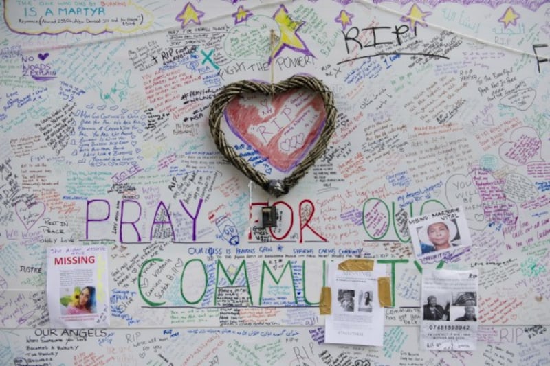 Tributes and missing posters are left on a wall near Grenfell Tower (David Mirzoeff/PA)
