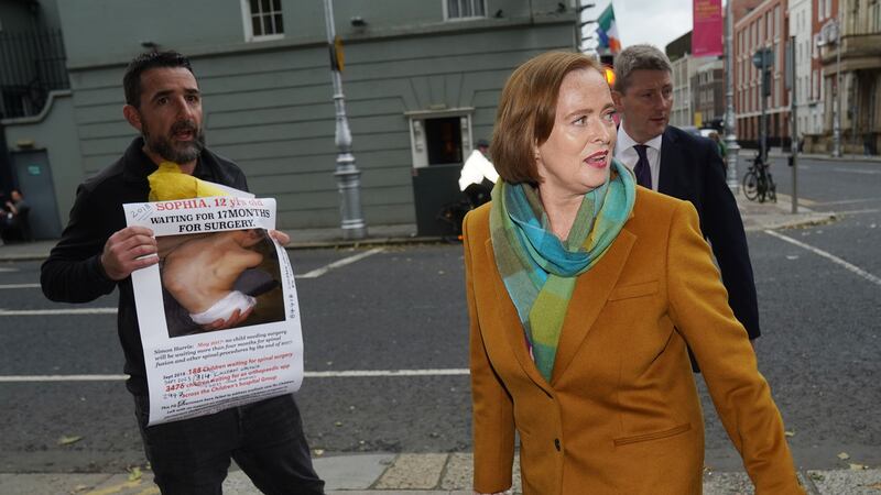 A protester shows a picture of his daughter to Eilish Hardiman outside Leinster House in Dublin (Brian Lawless/PA)