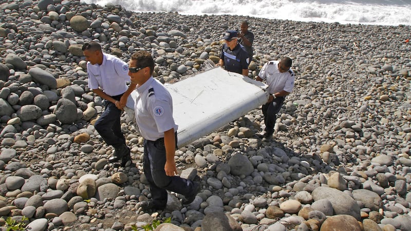 French police officers carry a piece of debris from a plane known as a &quot;flaperon&quot; on the shore of Saint-Andre, Reunion Island in July. Picture by Lucas Marie, Associated Press&nbsp;