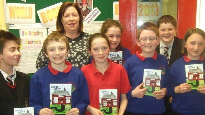 Pauline McGarry with pupils from Crumlin Integrated College and Gaelscoil Ghleann Daragh who provided the illustrations for Hilltop School 