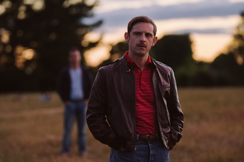 A scene from All of Us Strangers showing Jamie Bell as Dad and Andrew Scott as Adam standing in a field