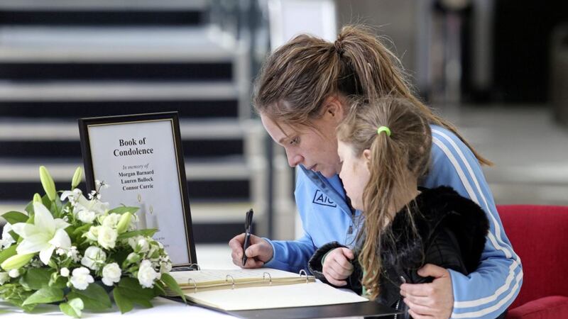 A mother and daughter sign the book of condolence at the Burnavon Centre in Cookstown. Picture by Mal McCann 