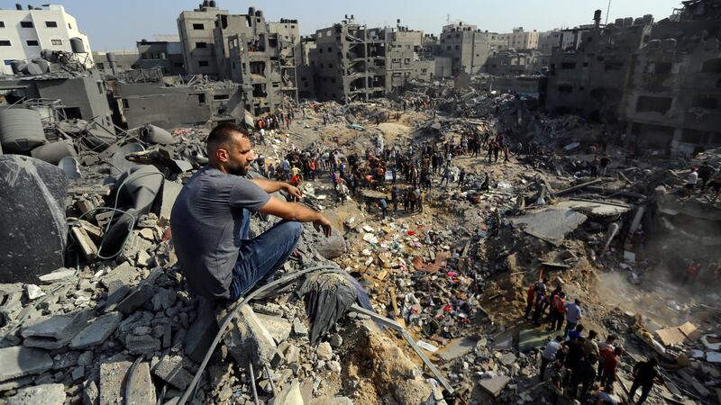 A man sits on the rubble overlooking the debris of buildings that were targeted by Israeli airstrikes in the Jabaliya refugee camp (Abed Khaled/AP)