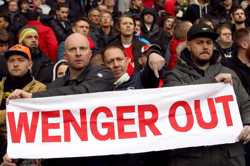 Fans hold up a Wenger Out banner in the stands