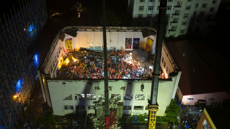 Rescuers conduct a search and rescue operation at the gym (Zhang Tao/Xinhua/AP)