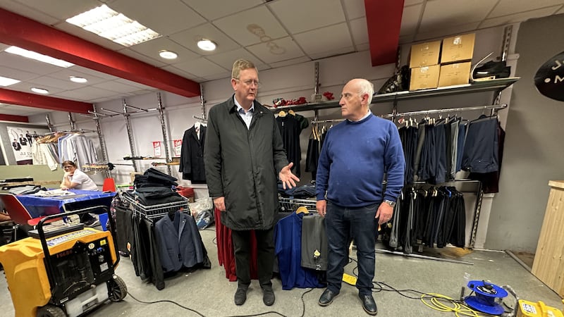 Lord Caine speaking with Brian Rogers of JJ Donnelly Menswear in Downpatrick who has had his business damaged by flood water (Liam McBurney/PA)