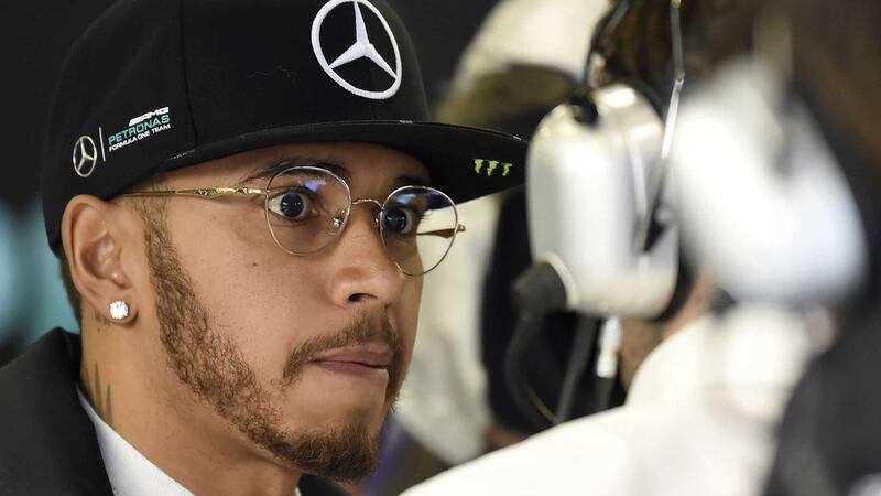 Mercedes driver Lewis Hamilton of Britain speaks to a team technician while he stands in his garage during the second practice session at the Australian Formula One Grand Prix at Albert Park in Melbourne, Australia