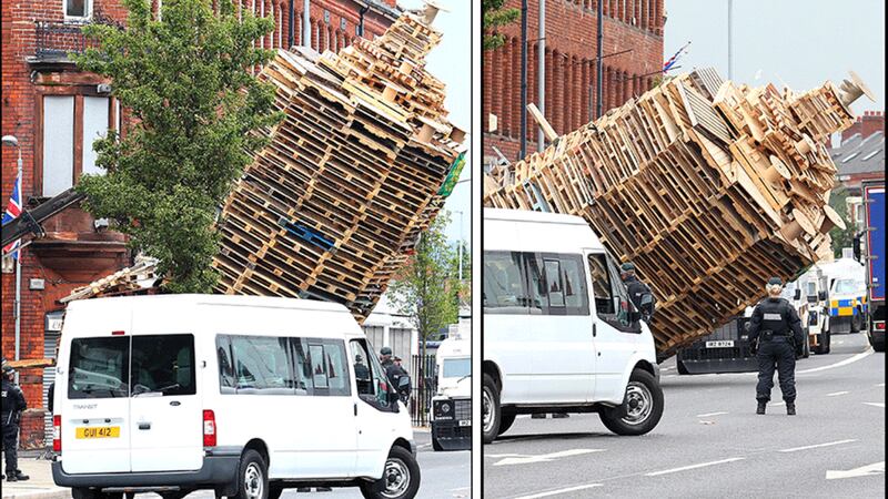 &nbsp; Cluan Place bonfire is pushed over by machinery before being removed from the site. Pictures by Mal McCann
