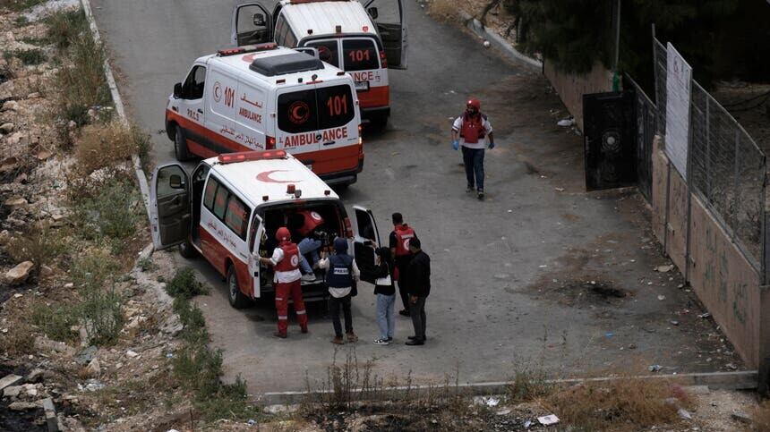 Palestinian Red crescent paramedics evacuate a journalist injured when he was shot while filming fighting between Israeli forces and Palestinian militants in the West Bank city of Jenin (AP)